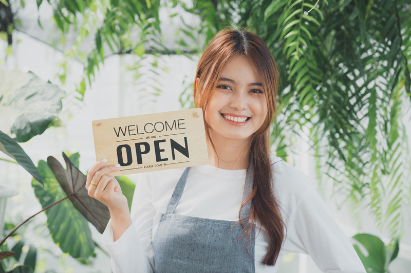 portrait-of-cheerful-owner-standing-at-market-stal-2023-11-27-05-17-53-utc